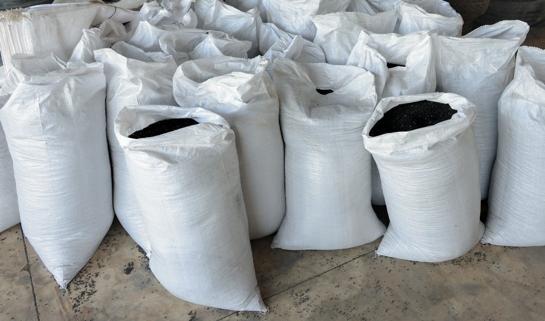 Open white sacks filled with black rubber granules at Bedrock's plant